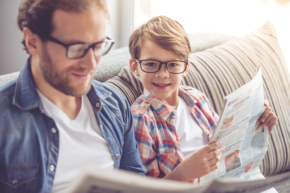 Father and son reading newspaper